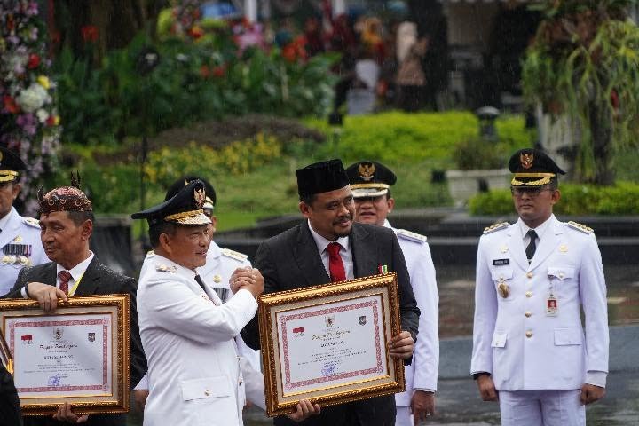 Menteri Dalam Negeri Tito Karnavian menyerahkan penghargaan Satyalencana kepada Wali Kota Medan Bobby Nasution dalam acara Peringatan Hari Otonomi Daerah XXVIII tahun 2024 di Surabaya, Jawa Timur Kamis 25 April 2024. Humas Pemkot Surabaya