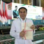 RP. Antonius Wahyuliana, CM (Romo Wahyu) menunjukkan sertipikat Gereja Katolik Fransiskus Asisi usai penyerahan oleh Menteri ATR/BPN Nusron Wahid di Masjid Nasional Al-Akbar Surabaya, Sabtu (13/12/2025).