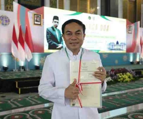 RP. Antonius Wahyuliana, CM (Romo Wahyu) menunjukkan sertipikat Gereja Katolik Fransiskus Asisi usai penyerahan oleh Menteri ATR/BPN Nusron Wahid di Masjid Nasional Al-Akbar Surabaya, Sabtu (13/12/2025).