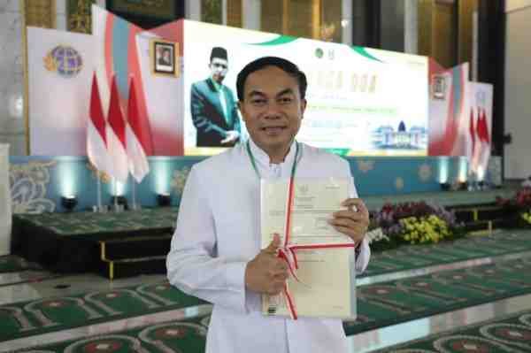 RP. Antonius Wahyuliana, CM (Romo Wahyu) menunjukkan sertipikat Gereja Katolik Fransiskus Asisi usai penyerahan oleh Menteri ATR/BPN Nusron Wahid di Masjid Nasional Al-Akbar Surabaya, Sabtu (13/12/2025).