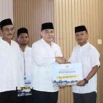 Wakil Menteri ATR/Wakil Kepala BPN, Ossy Dermawan, didampingi Sekjen ATR/BPN Dalu Agung Darmawan menyerahkan bantuan kepada ASN asal Aceh terdampak bencana dalam kegiatan Silaturahmi dan Buka Puasa Bersama di Masjid Nuurur Rahman ATR/BPN, Jakarta, Kamis (26/2/2026).