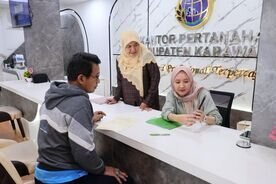 Seorang warga mengambil sertipikat tanah di Kantor Pertanahan Kabupaten Karawang melalui layanan Pelayanan Tanah Akhir Pekan (PELATARAN) yang tetap dibuka untuk memudahkan masyarakat mengurus dokumen pertanahan di hari libur.