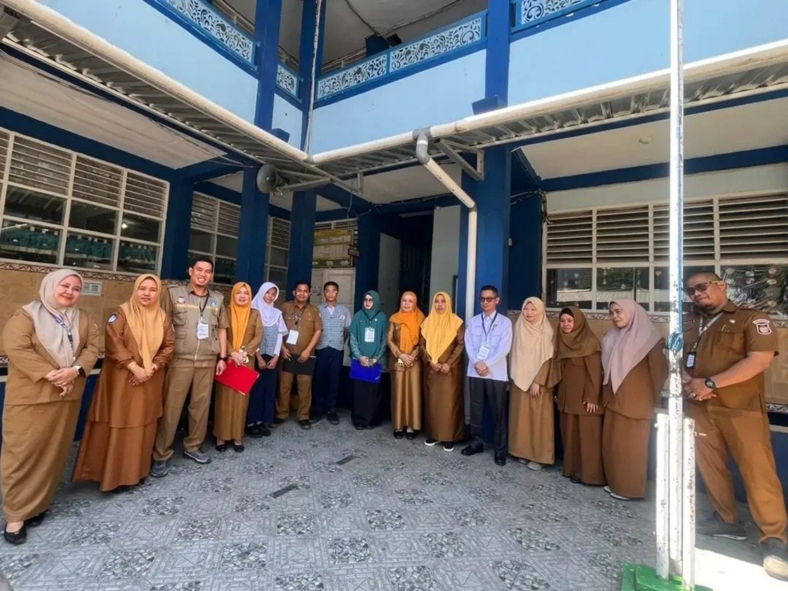 Tim penilai lomba UKS dan pihak SMPN 29 Makassar berfoto bersama di lingkungan sekolah.
